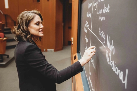 behavioral research scientist Alison Wood Brooks writes on a chalkboard