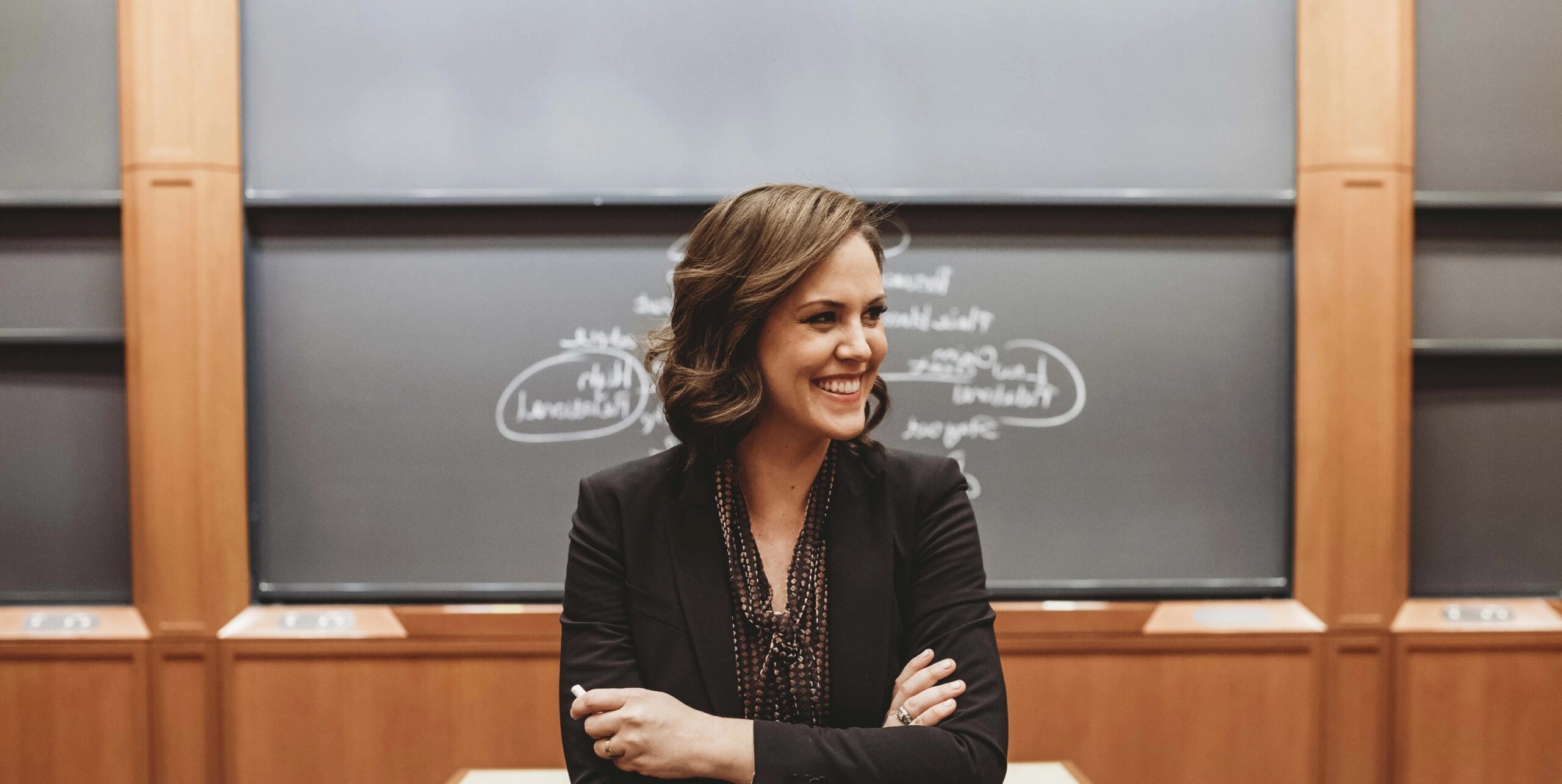 behavioral research scientist Alison Wood Brooks in front of a chalkboard